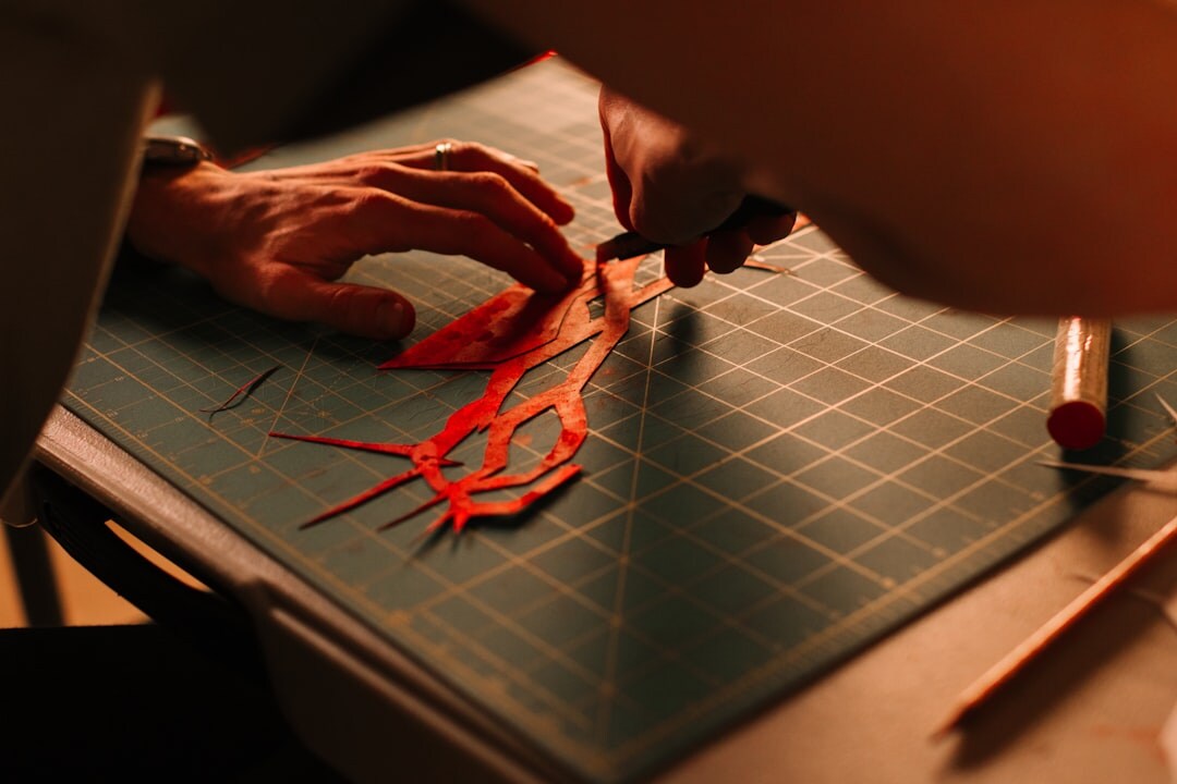 Hands reviewing printed documents with a red pen and magnifying glass
